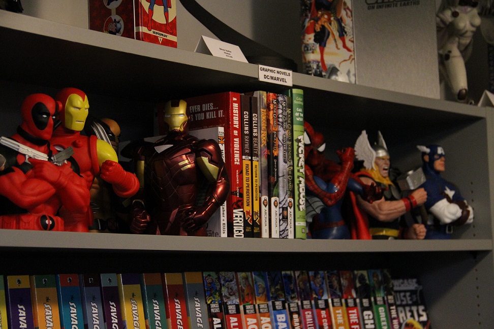 Several figurines of familiar comic book characters sit atop a shelf.