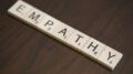 Stock photo of wooden Bananagrams tiles spelling out "EMPATHY"