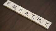 Stock photo of wooden Bananagrams tiles spelling out "EMPATHY"