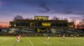 Photo of McDaniel's main sports field during sunset as a game is played.