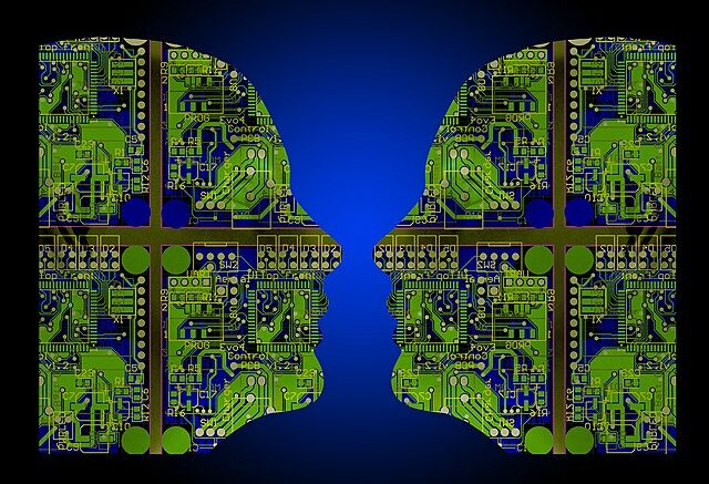 Side profile of two human faces filled with green computer components and technologies, on a blue background.